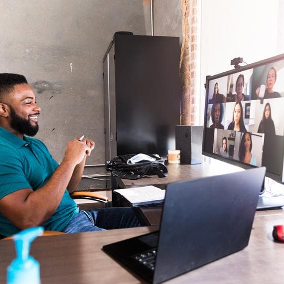 Man looking a screen where a virtual meeting is taking place